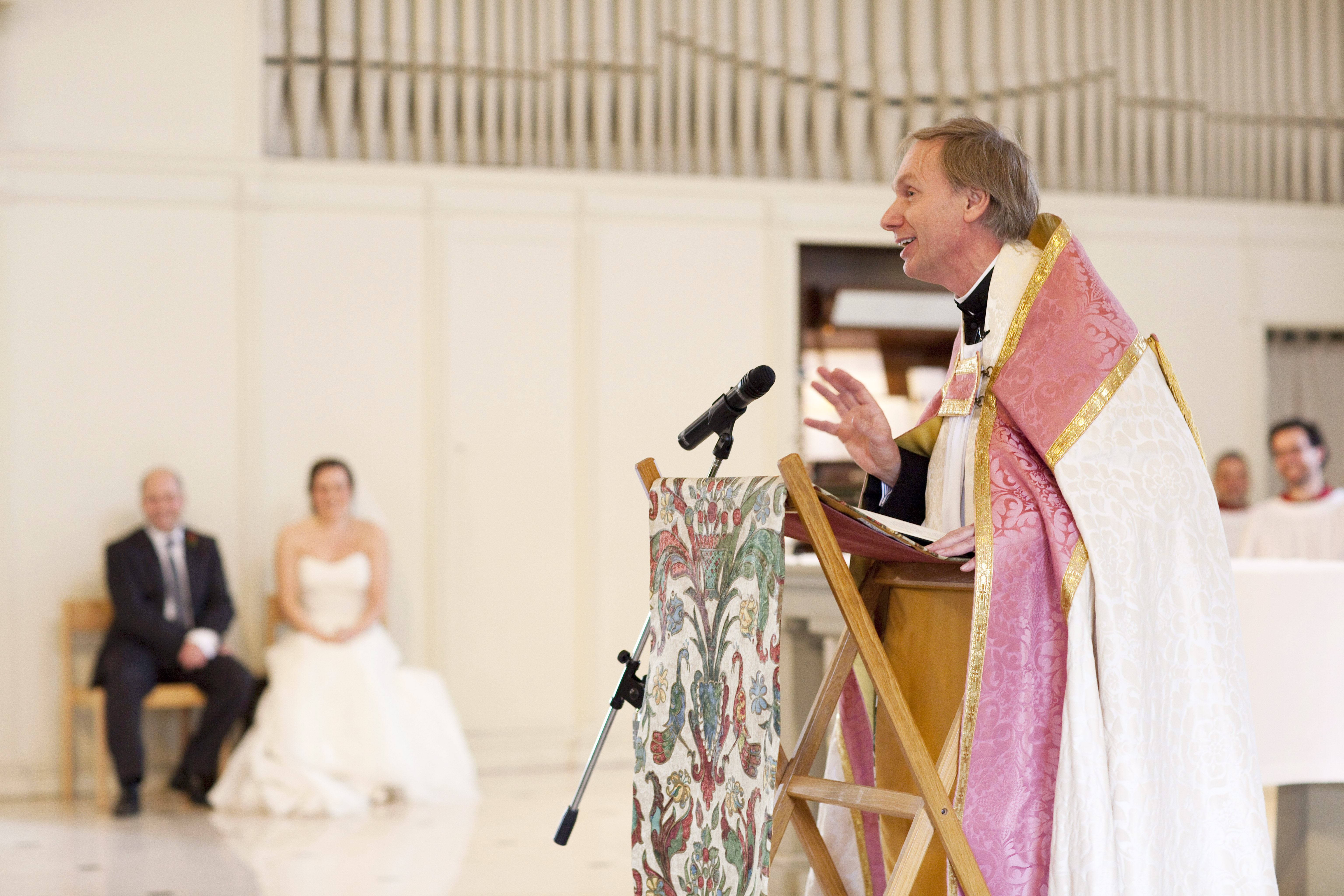 Our vicar, Anders Bergquist, preaching at a wedding, with the couple in the background. Photograph taken by Helen Maybanks.